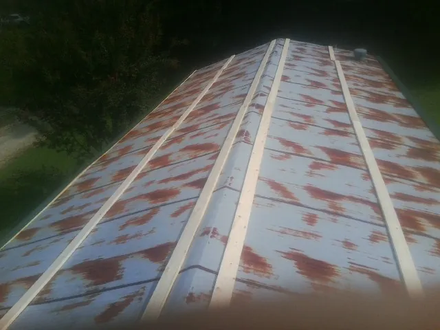Rusted metal roof panels with new wood purlins before replacement — Storm Damage Roof Repair in Newburyport by Roofing Brothers