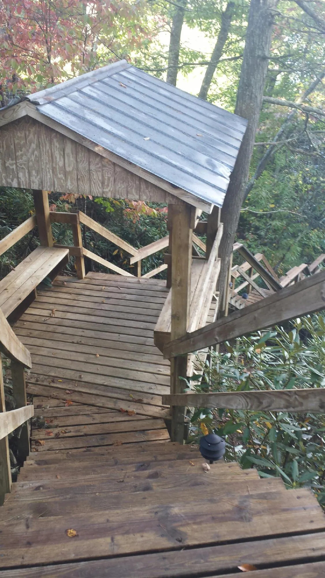 Metal roofed shelter over wooden steps on a wooded walkway — Skylight Repair & Installation work by our crew in Newburyport