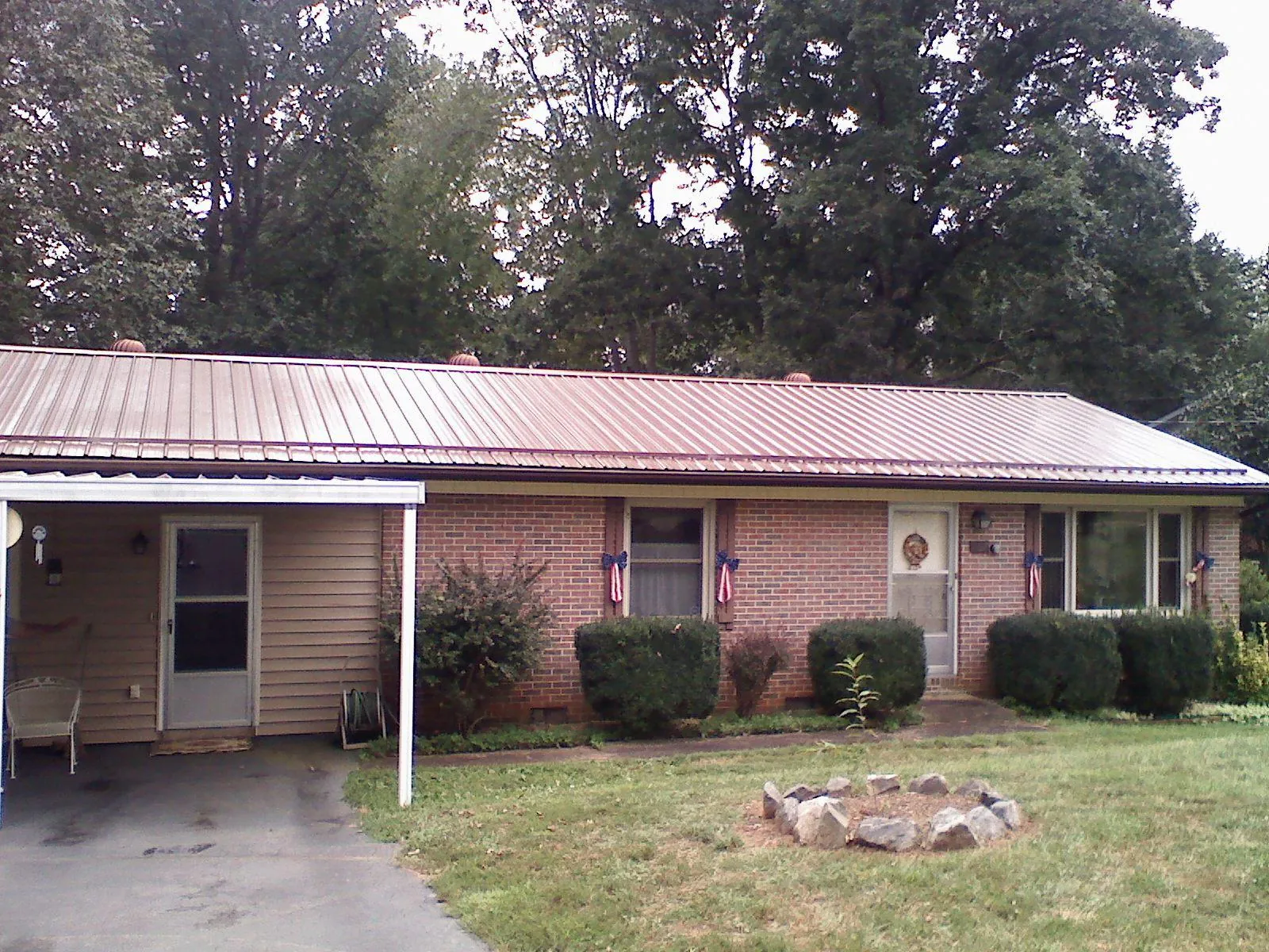 Bronze metal roof and carport on a brick ranch home — Roof Repair work by our crew in Newburyport